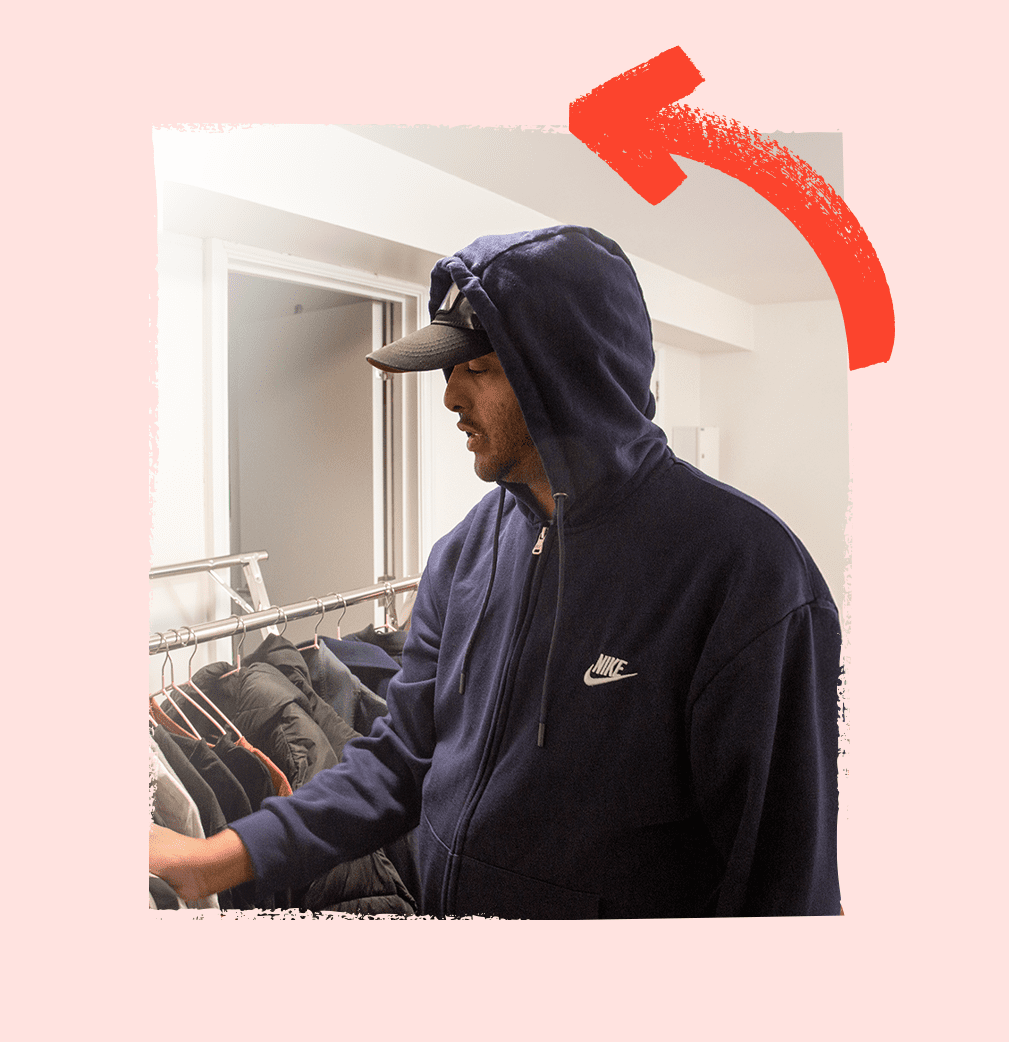 Service user selecting clothes from his wardrobe, thoughtfully choosing items to wear.