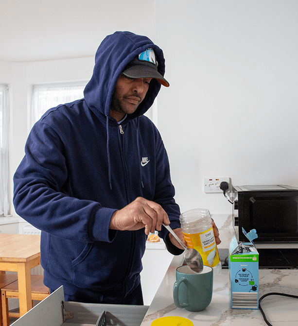 Service user preparing a cup of tea in a cozy kitchen setting